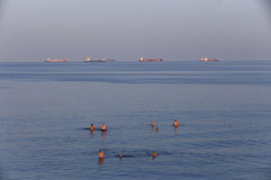 Baigneurs et bateaux à l'horizon sur la Mer Baltique à Skagen au Danemark.