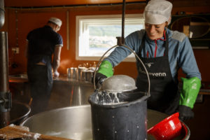 Un homme, fromager, et une femme, fromagère, travaillent dans la fromagerie de l'alpage de Nupshadlene en Norvège