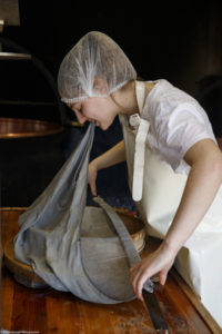 Une jeune femme, fromagère, prépare la toile avec laquelle elle va soutirer le caillé pour la fabrication du fromage, à la ferme Chez Valentin à Foncine-le-Haut