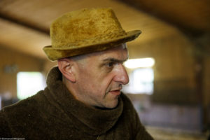 Portrait d'un homme, éleveur, portant un chapeau à la ferme de l'Eldorado à Indevillers dans le Doubs