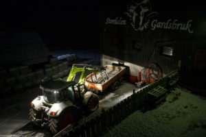 Tracteur vert et remorque rouge sous la neige à Austbygde en Norvège.