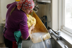 Lavage du beurre dans un baquet en bois utilisé pour la fabrication de beurre fermier à Våler en Norvège.