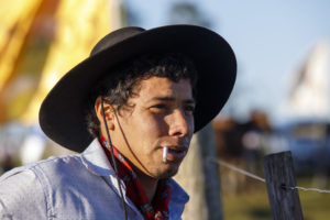 Portrait d'un jeune homme avec chapeau et cigarette à la bouche, lors d'une "jineteada", l'équivalent du rodéo aux Etats-Unis, près de Tacuarembo en Uruguay.