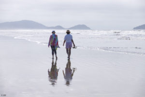 Deux femmes marchent sur une plage de l'Océan Atlantique sud à Atami au Paraná.